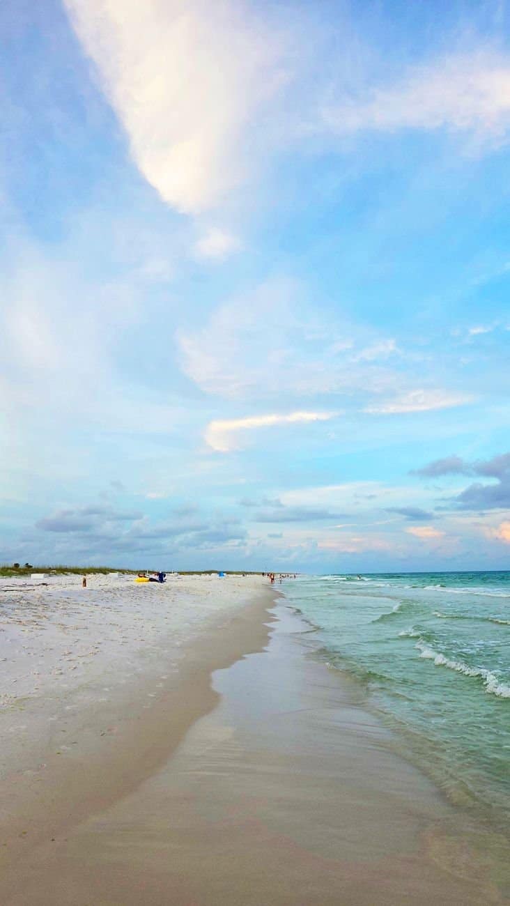 Capture of a tranquil beach in Florida featuring white sand and clear blue skies perfect for relaxation.
