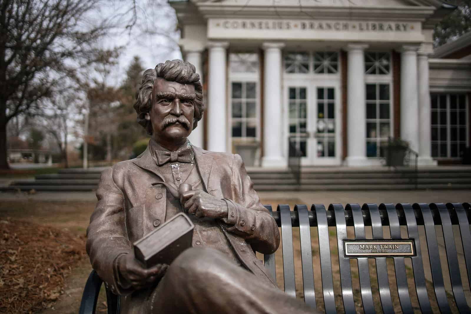 Bronze statue of Mark Twain outside Cornelius Branch Library. Prominent literary figure captured in art.