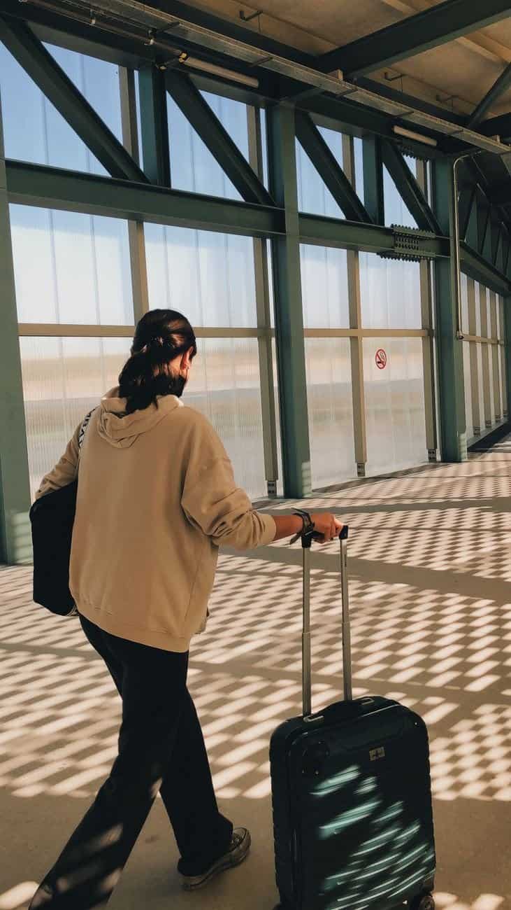 A traveler navigating a busy unfamiliar train station with luggage