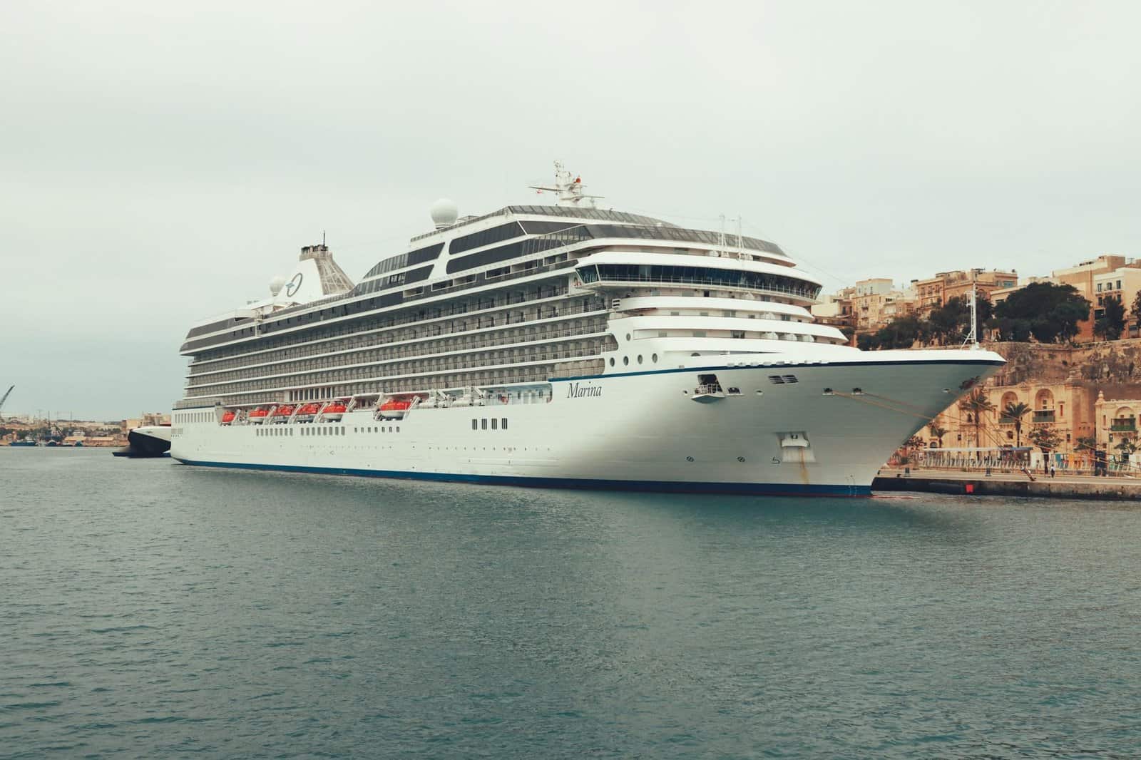 A large cruise ship docked at a coastal port town