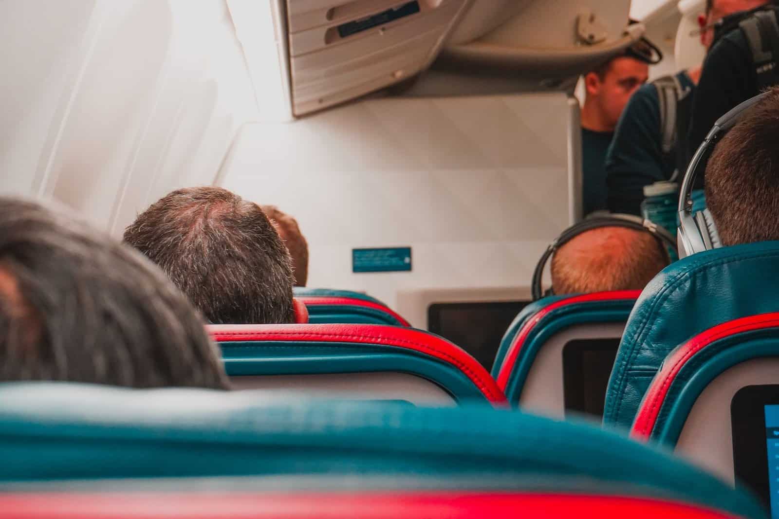 Rows of narrow economy class airline seats