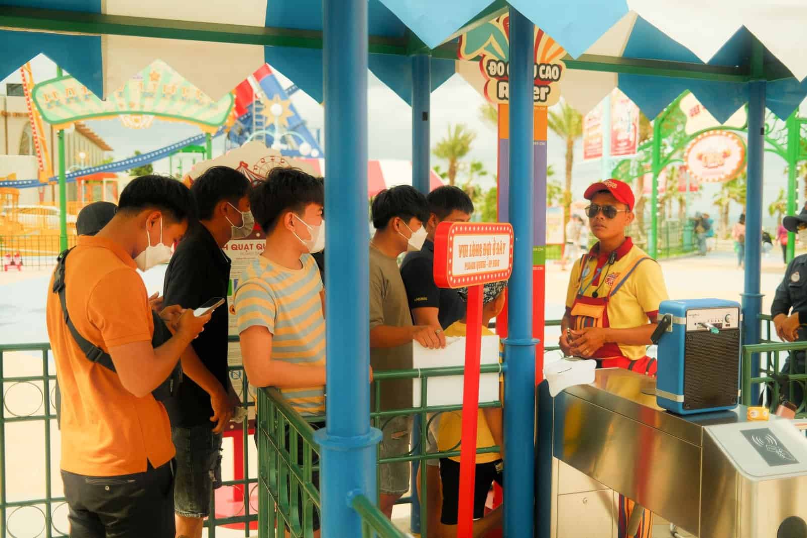 Crowds of visitors walking through a theme park entrance