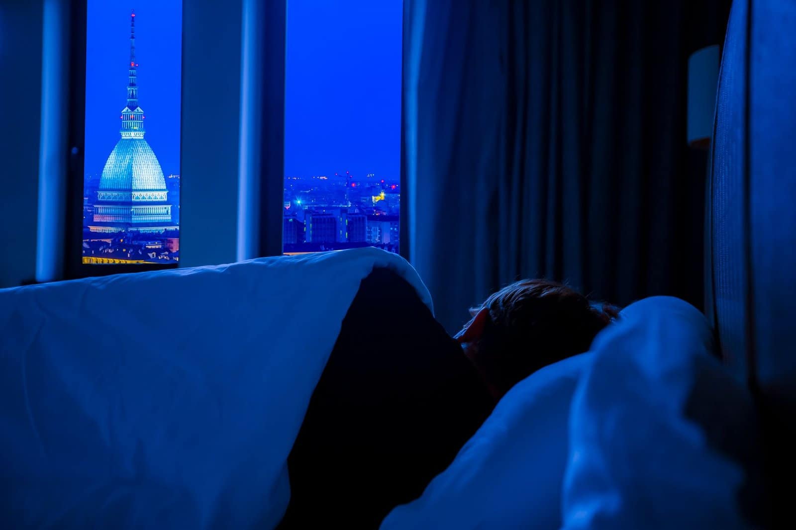 A softly lit hotel bedroom designed for optimal sleep
