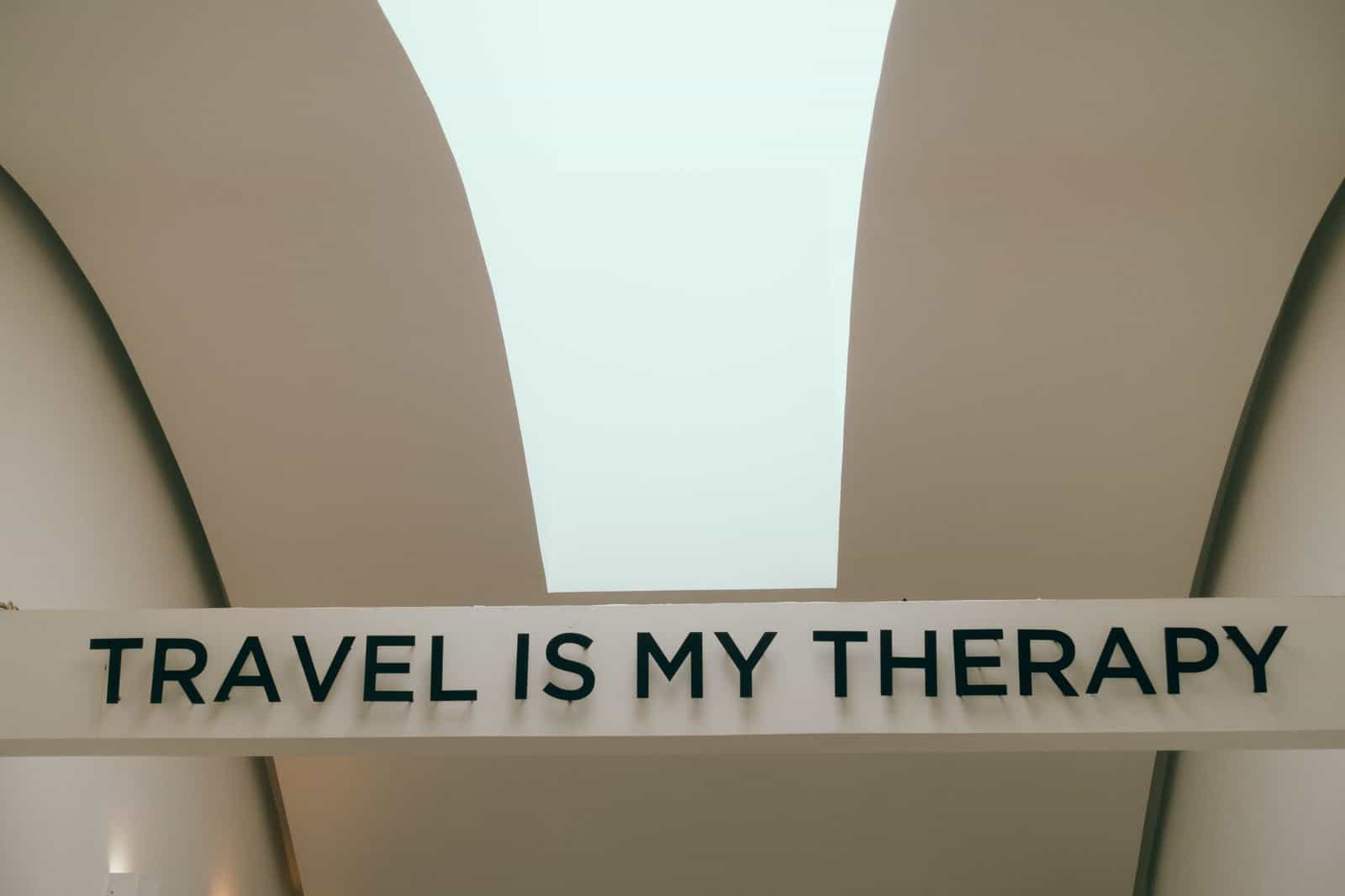 A motivational travel quote displayed in a minimalist interior setting.