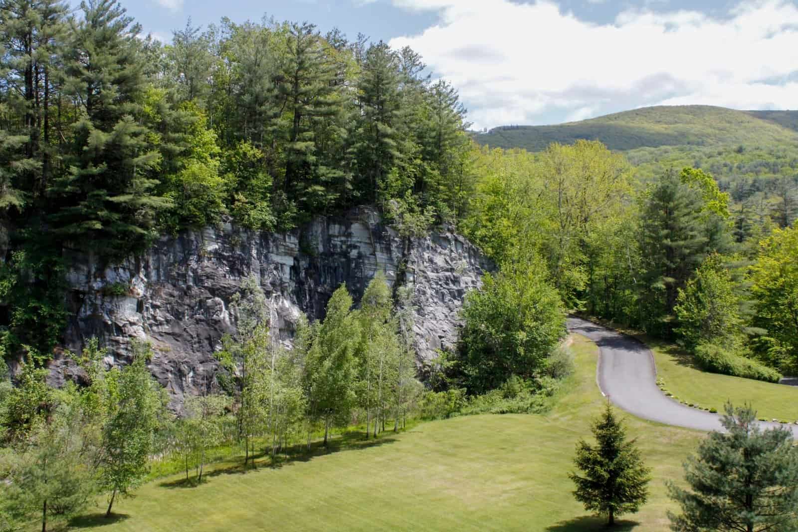 Captivating aerial shot of lush greenery and rocky cliff in North Adams, MA, USA.