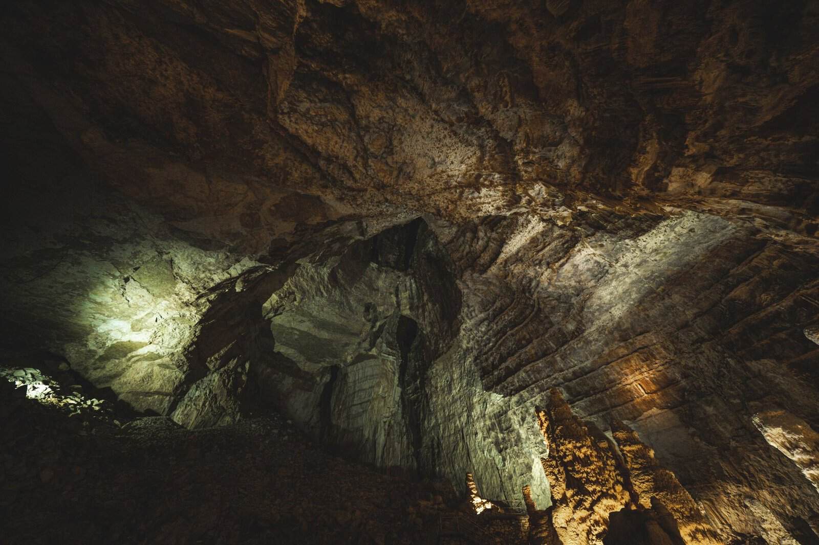 Explore the depth and textures of a dramatic underground cave with intricate rock formations.