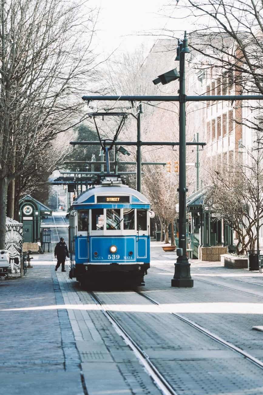A blue tram travels through the leafless winter streets of downtown Memphis, Tennessee.