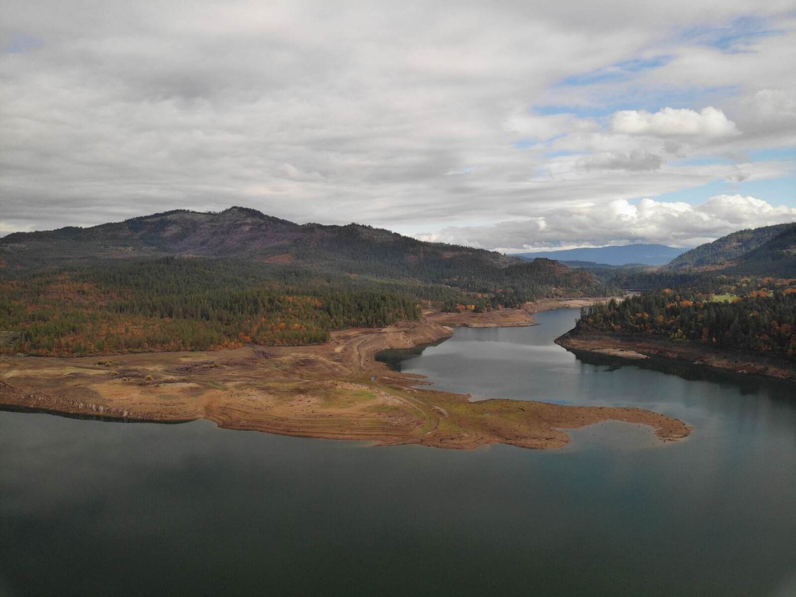 Aerial view of Rogue River in McLeod, Oregon showcasing serene water and mountain landscape.