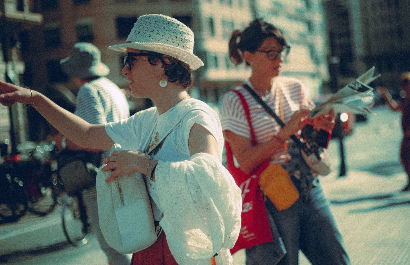 Two women enjoy a sunny day in the city, pointing and navigating with a map.