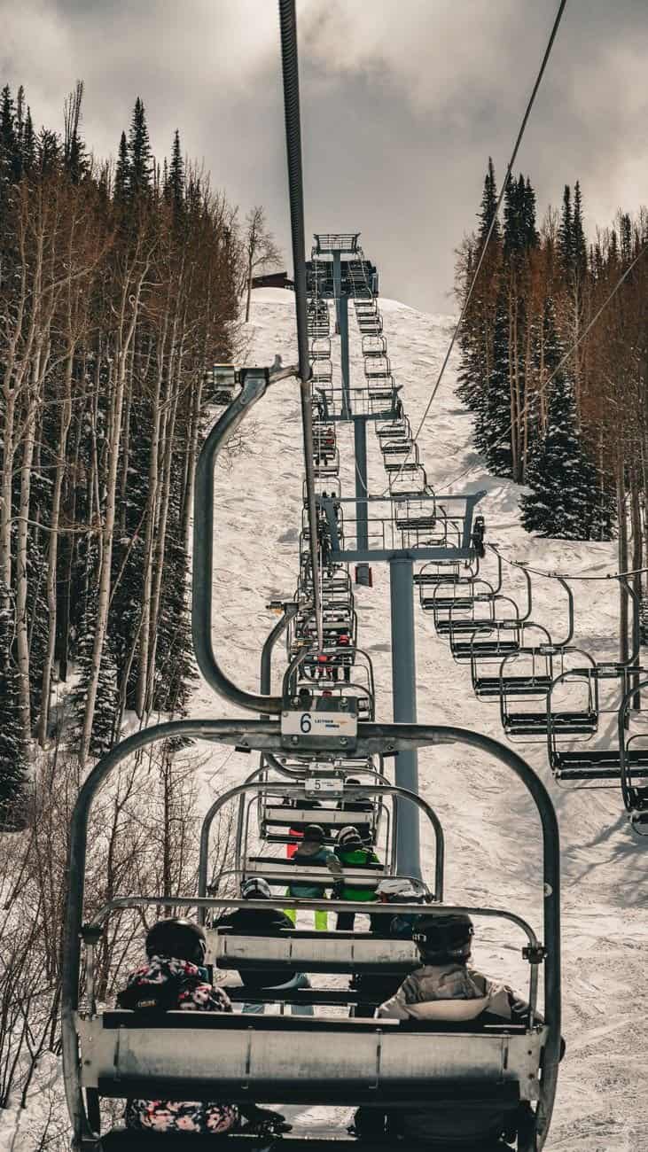 Ski lift carrying skiers on a snowy winter day in Steamboat Springs, Colorado.