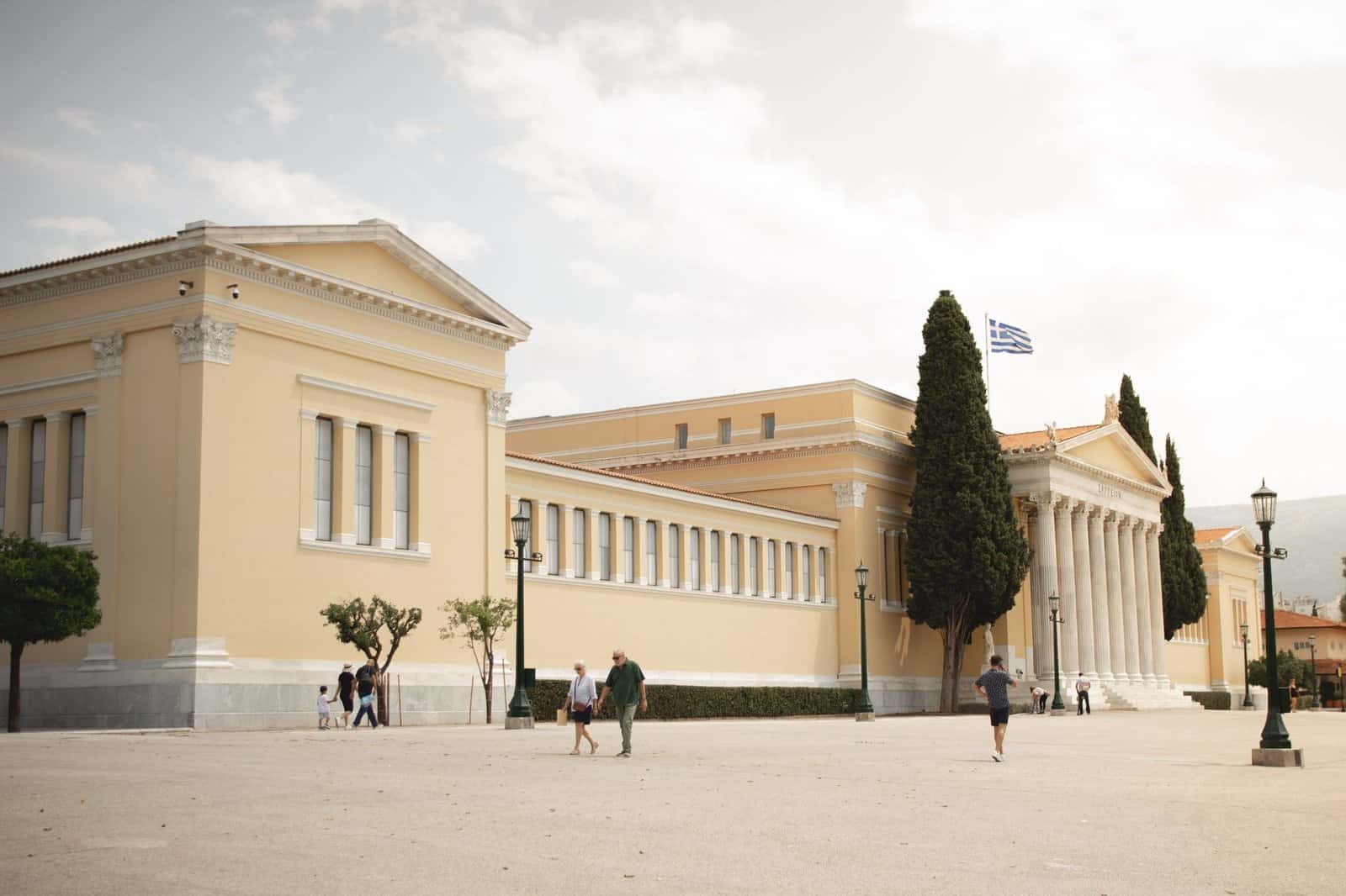 Zappeion Hall's neoclassical architecture in Athens featuring columns and Greek flag.