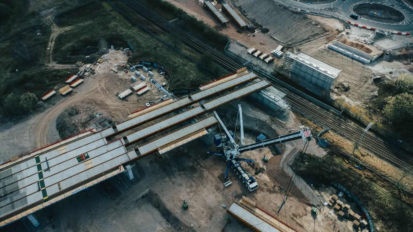 A birds-eye view of a highway construction site with machinery and structures.