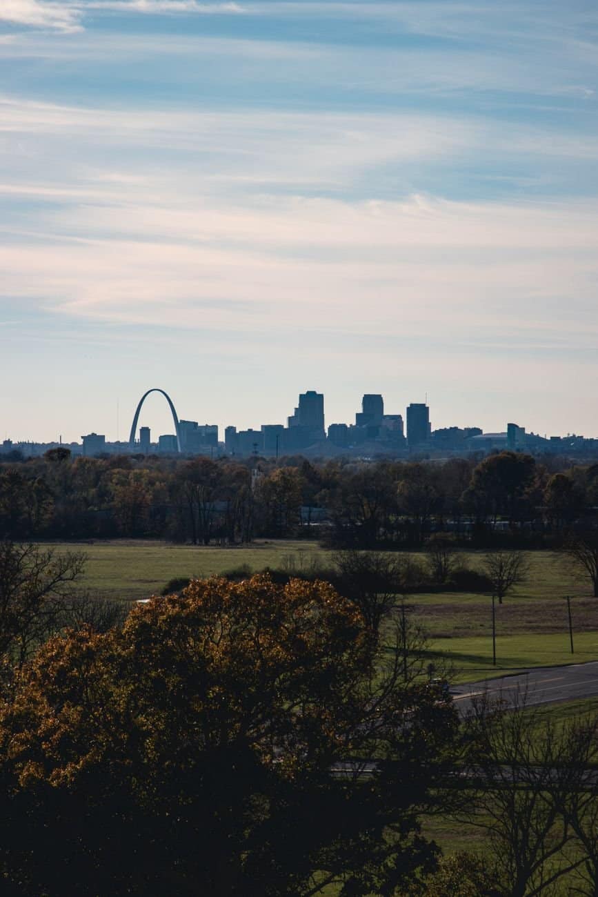 A scenic view of the St Louis skyline featuring the iconic Gateway Arch under a clear blue sky.