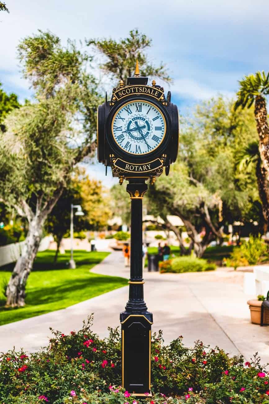 Elegant vintage clock in Scottsdale's outdoor park with lush greenery.