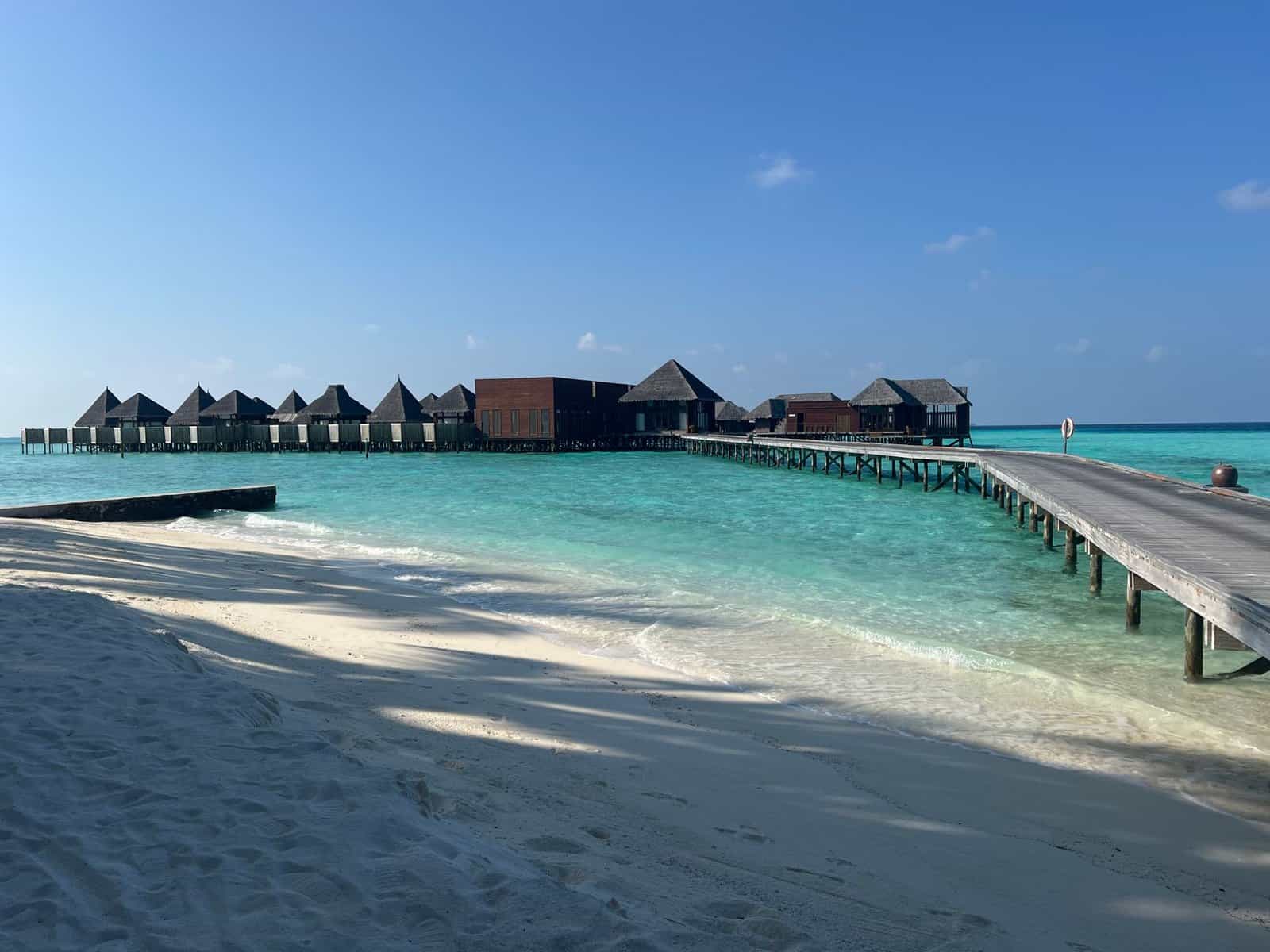 Stunning overwater villas in Maldives with a serene view of turquoise sea and sandy beach.