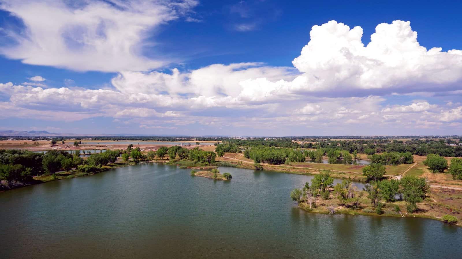 Scenic aerial view of a serene lake surrounded by lush greenery in Fort Collins, Colorado.