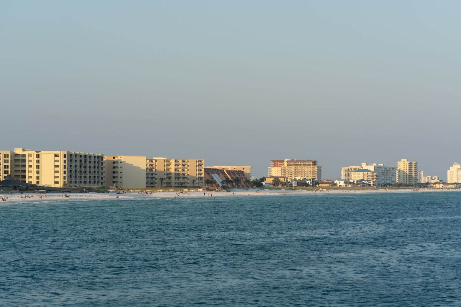 Sunset view of Destin, FL beachfront with modern architecture and serene ocean.