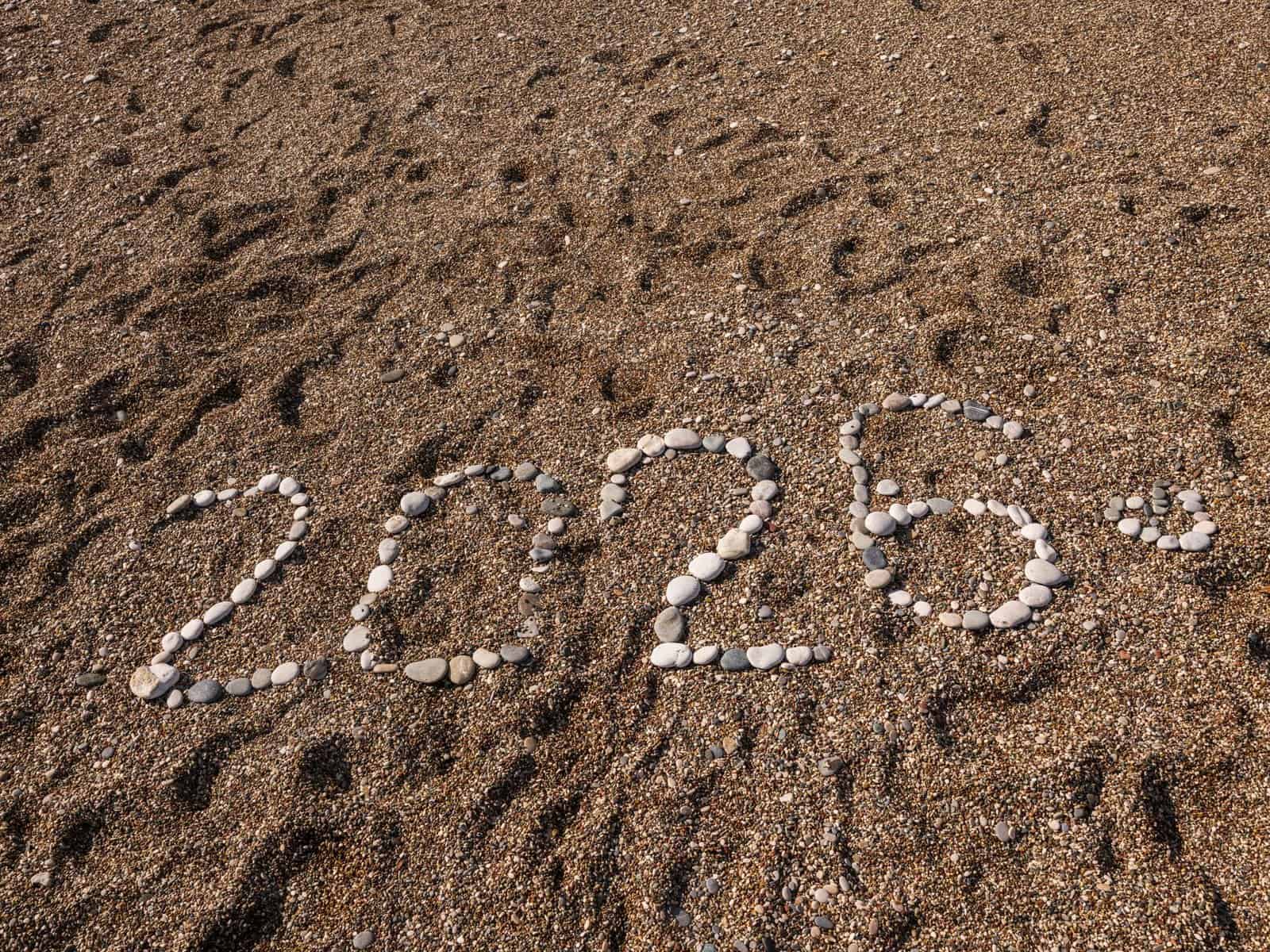 Stones arranged to form the number 2026 on a sandy coastline, creating a natural and creative scene.