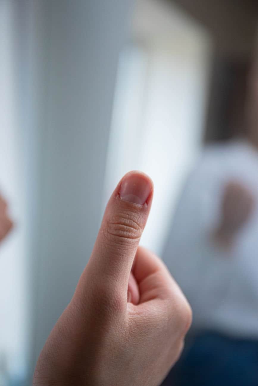 A focused shot of a hand making a thumbs up gesture, symbolizing approval or success.