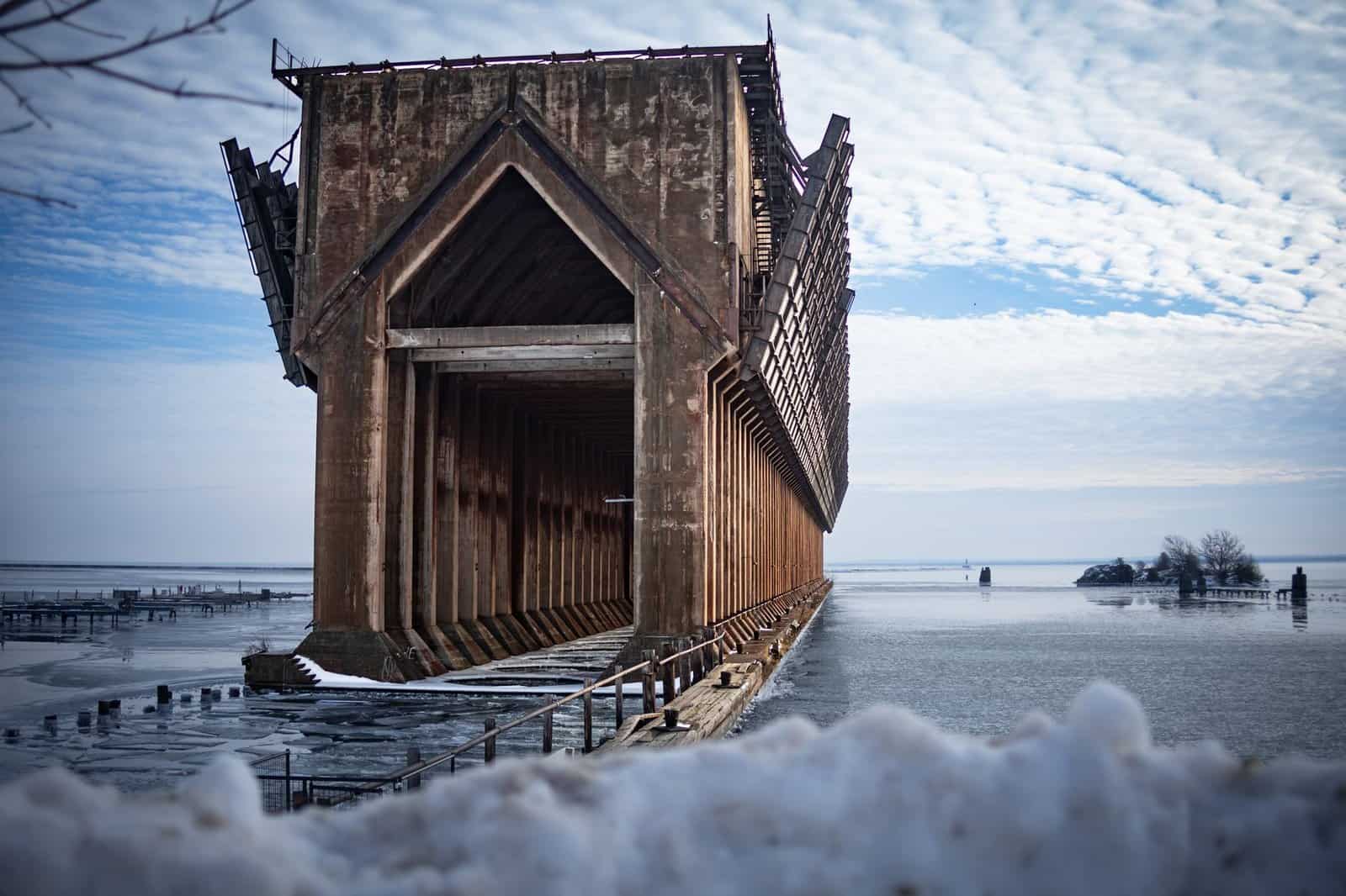 A stunning view of the abandoned ore dock in a snowy winter landscape by Lake Superior in Marquette, MI.