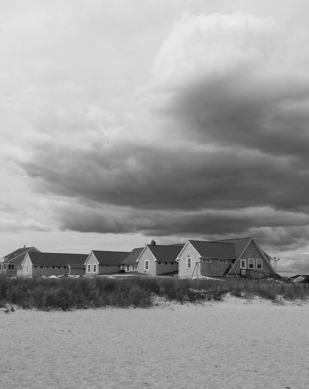 Monochrome view of coastal homes under dramatic skies in Massachusetts.