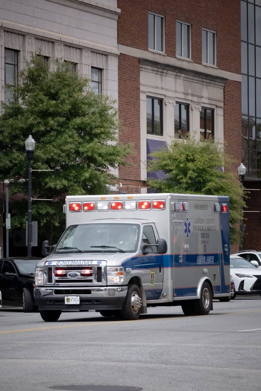 An emergency ambulance vehicle driving down a city street in Macon, Georgia.