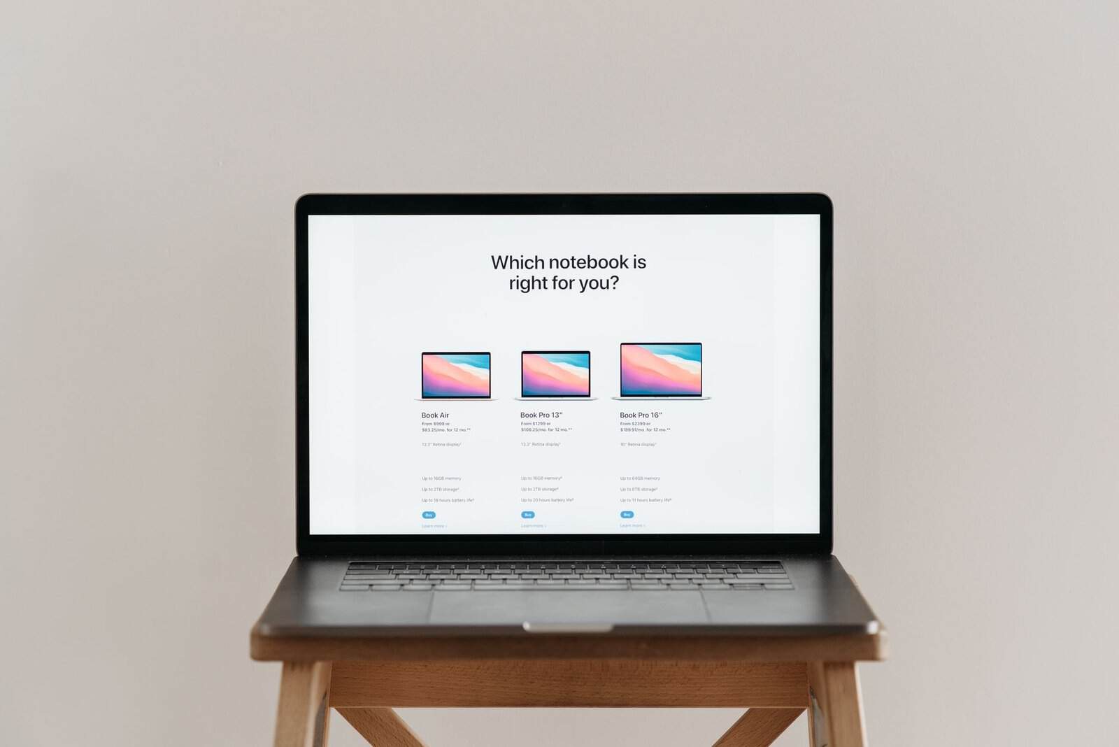An open laptop on a wooden stool showing a notebook comparison chart, ideal for tech-focused imagery.